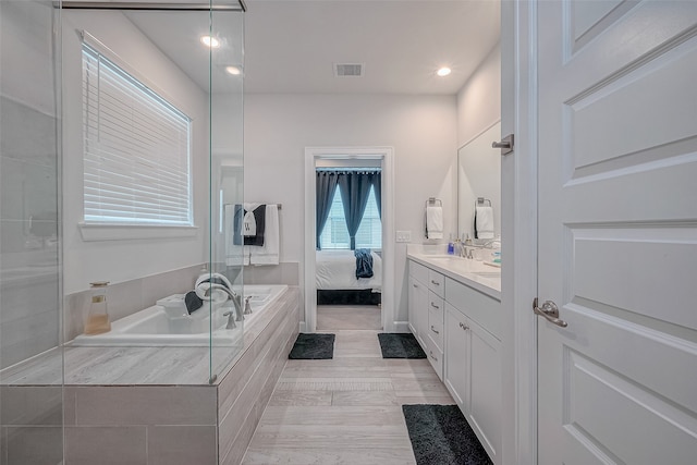 bathroom with tiled bath and vanity