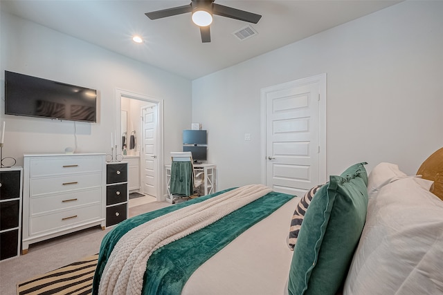 bedroom featuring light carpet, ceiling fan, and ensuite bathroom