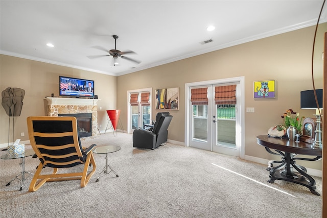 sitting room with a fireplace, carpet flooring, ceiling fan, and ornamental molding