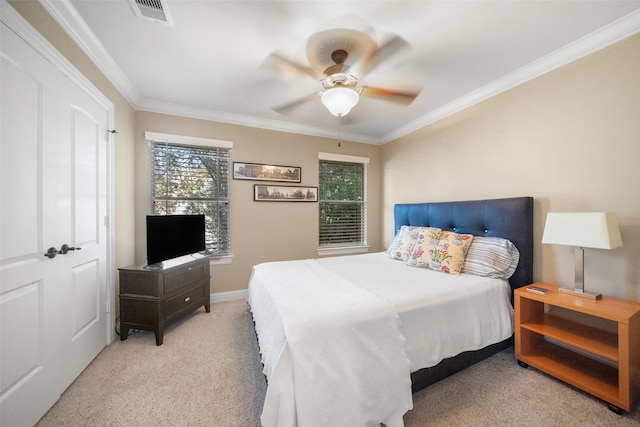 carpeted bedroom with ceiling fan and ornamental molding