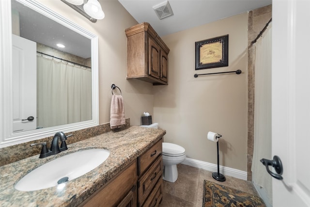 bathroom with tile patterned flooring, vanity, and toilet