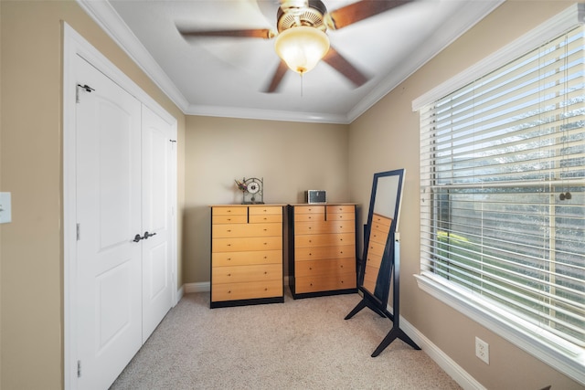 bedroom featuring ceiling fan, ornamental molding, light carpet, and a closet