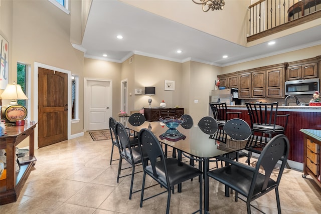 tiled dining room with a towering ceiling and ornamental molding