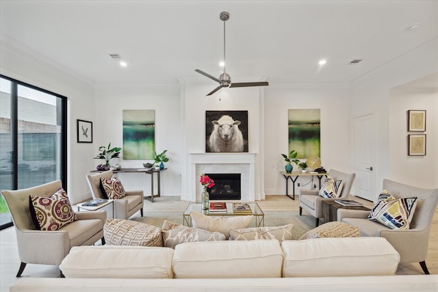 living room featuring ornamental molding, light hardwood / wood-style floors, and ceiling fan