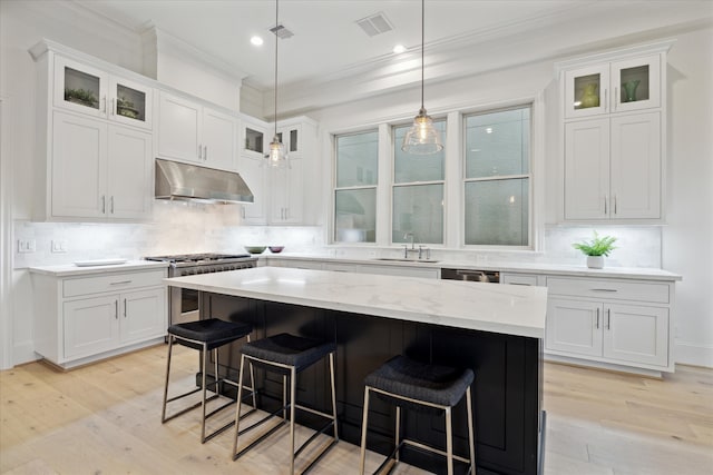 kitchen featuring light hardwood / wood-style flooring, a center island, and white cabinets