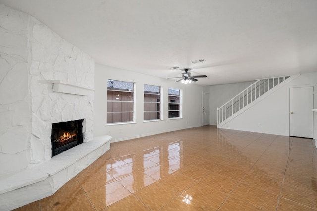 unfurnished living room featuring tile patterned flooring, a fireplace, and ceiling fan