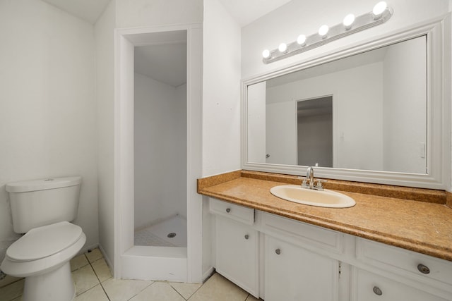 bathroom featuring tile patterned flooring, vanity, toilet, and walk in shower