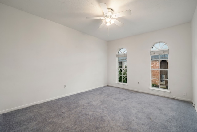 carpeted spare room featuring ceiling fan