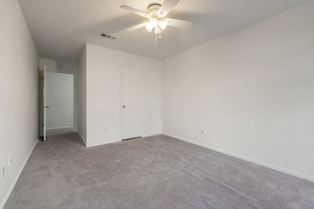 unfurnished bedroom featuring ceiling fan, light colored carpet, and a closet