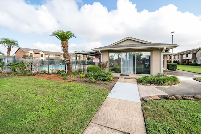 exterior space featuring a swimming pool and a lawn