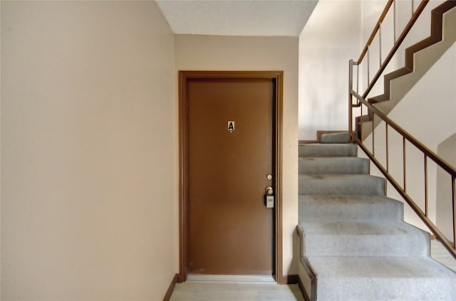 staircase featuring a textured ceiling