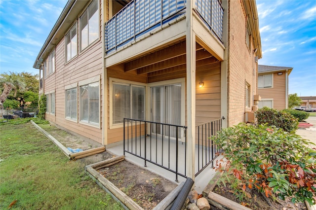 view of property exterior with a lawn and a balcony