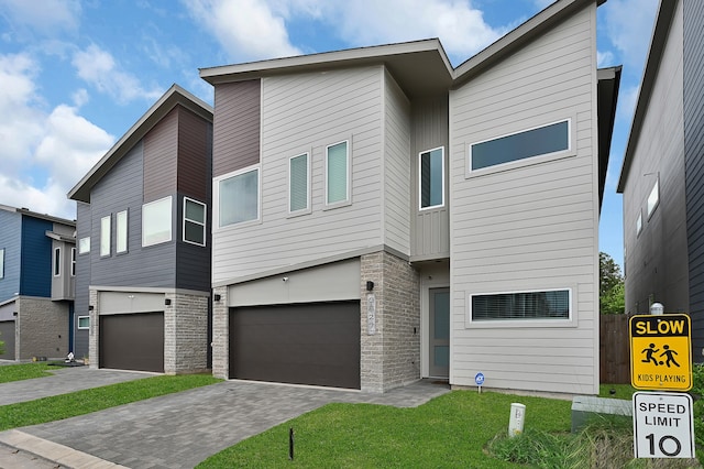 contemporary house featuring a garage and a front lawn