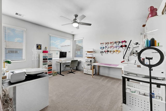 carpeted home office featuring ceiling fan