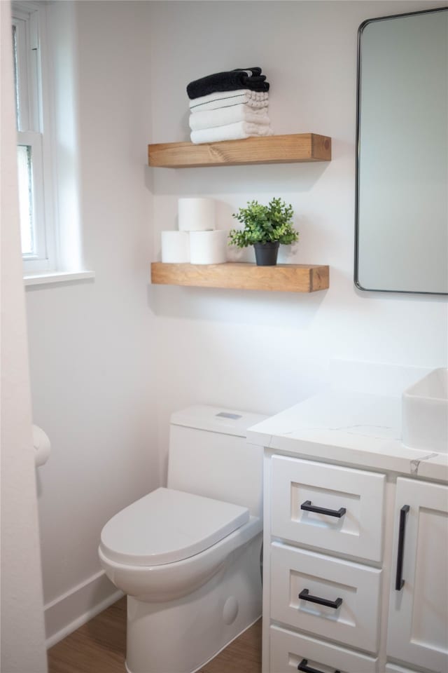 bathroom featuring vanity, hardwood / wood-style flooring, and toilet