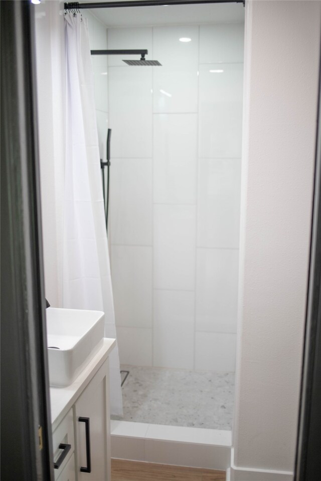 bathroom with curtained shower, vanity, and hardwood / wood-style flooring