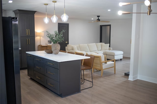 kitchen with hardwood / wood-style flooring, stainless steel fridge, pendant lighting, and a center island