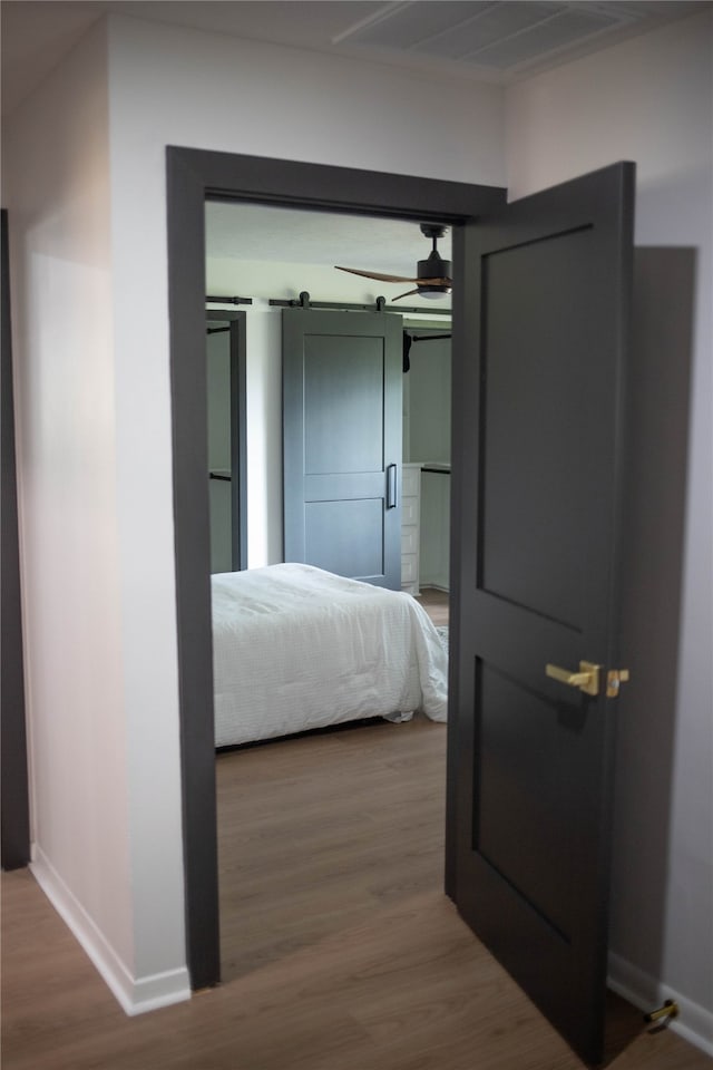 bedroom featuring a barn door and wood-type flooring