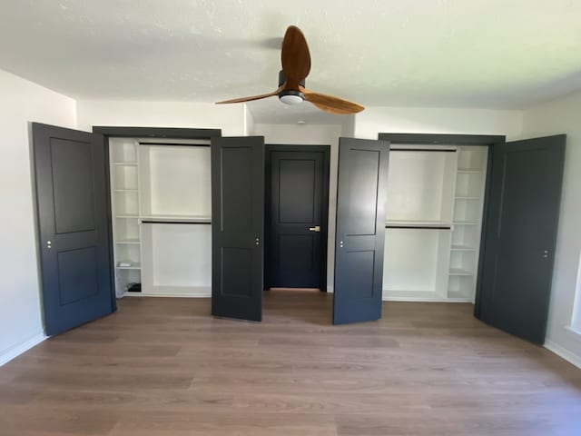 unfurnished bedroom featuring wood-type flooring and ceiling fan