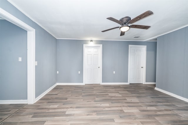 unfurnished room featuring ceiling fan, light wood-type flooring, and ornamental molding