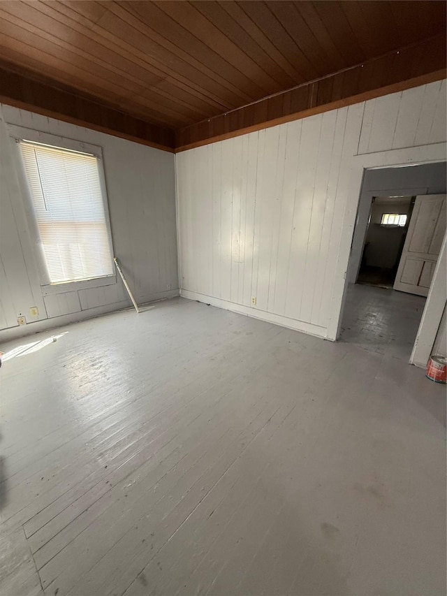 spare room featuring plenty of natural light, wood finished floors, and wood ceiling