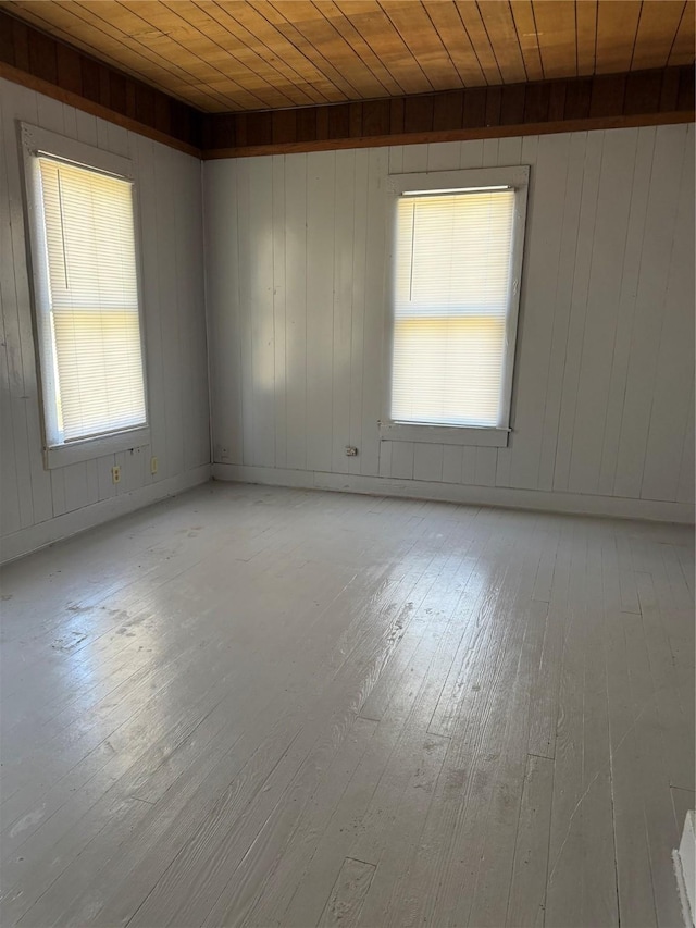 unfurnished room with wood ceiling and light wood-style flooring