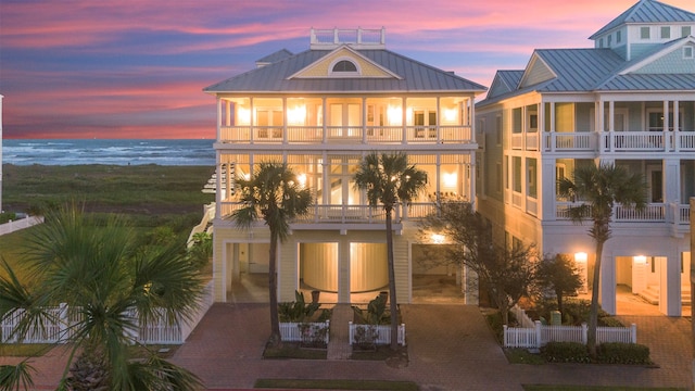 back house at dusk featuring a balcony