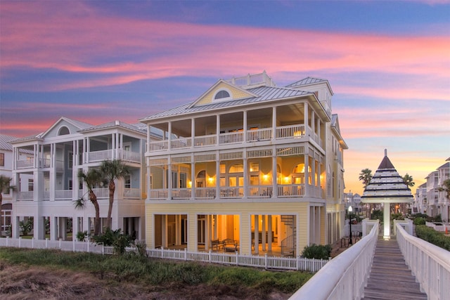 back house at dusk with a balcony