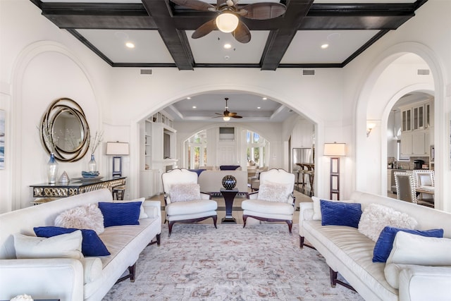 living room with coffered ceiling, ceiling fan, and beam ceiling