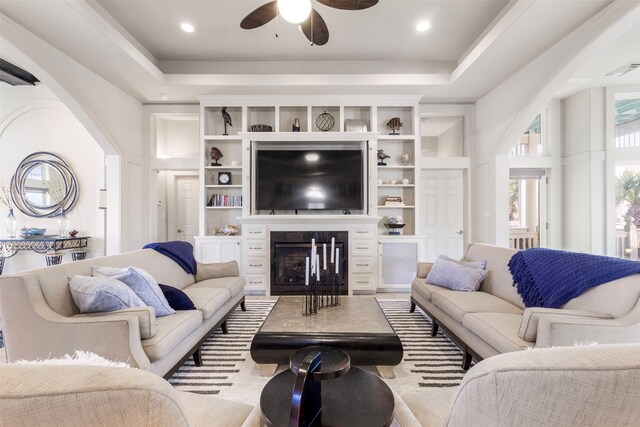 living room with ceiling fan and a tray ceiling