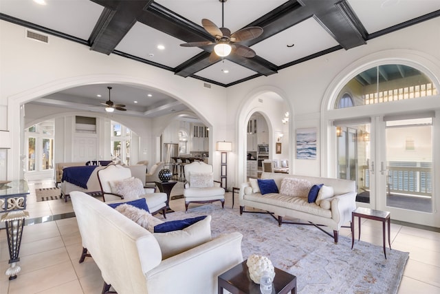 living room featuring beam ceiling, plenty of natural light, light tile patterned floors, and coffered ceiling