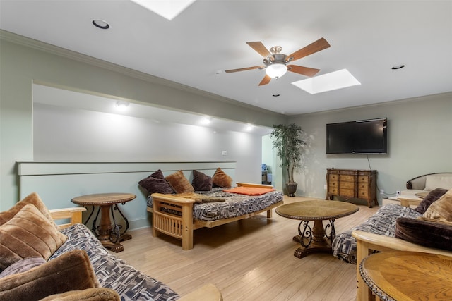 interior space featuring ornamental molding, light hardwood / wood-style flooring, ceiling fan, and a skylight