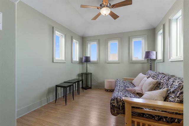 living room featuring ceiling fan, lofted ceiling, and light hardwood / wood-style floors