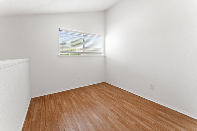 empty room featuring light hardwood / wood-style flooring and vaulted ceiling