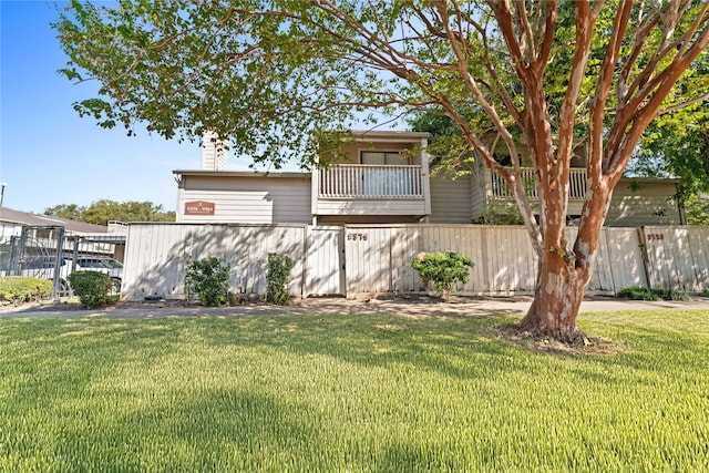 view of front of home featuring a front yard and a balcony