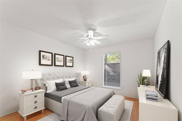 bedroom with a textured ceiling, light hardwood / wood-style flooring, and ceiling fan