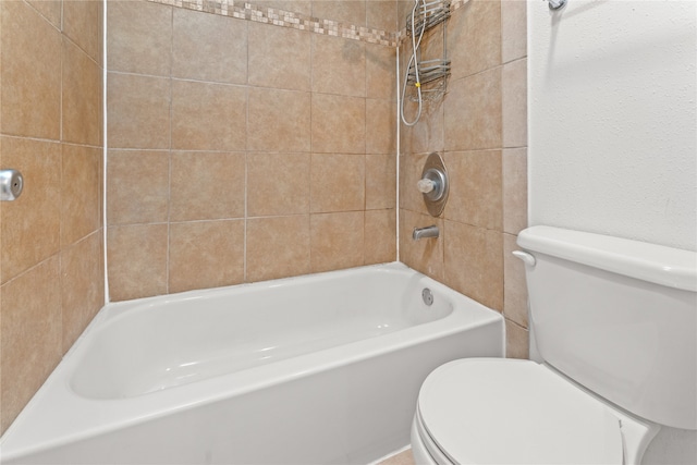 bathroom featuring tiled shower / bath and toilet