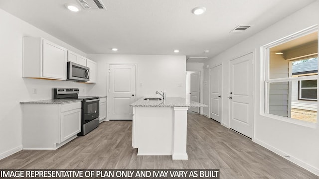 kitchen with stainless steel appliances, light hardwood / wood-style floors, a center island with sink, sink, and white cabinets