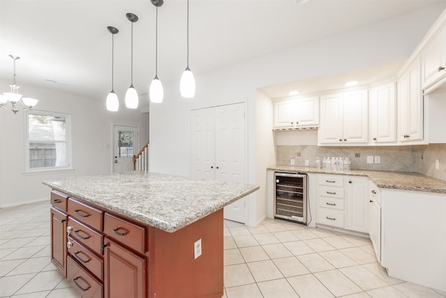 kitchen with wine cooler, backsplash, decorative light fixtures, and white cabinets