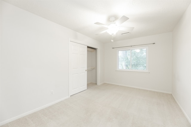 unfurnished bedroom with a closet, light carpet, and ceiling fan