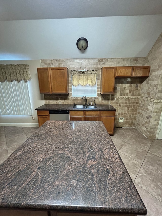 kitchen featuring light tile patterned flooring, stainless steel dishwasher, a wealth of natural light, and sink