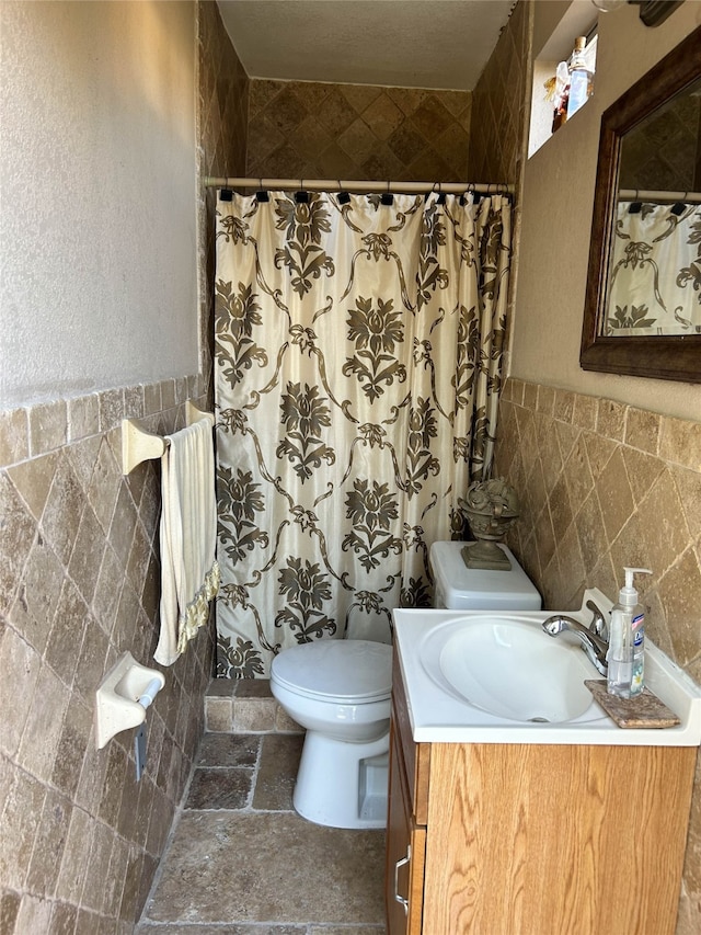 bathroom featuring a shower with curtain, vanity, and tile walls