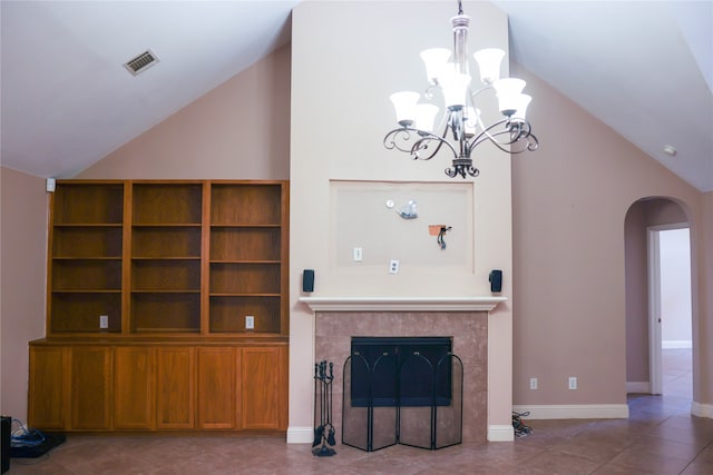 unfurnished living room featuring a tiled fireplace, tile patterned flooring, high vaulted ceiling, and a chandelier