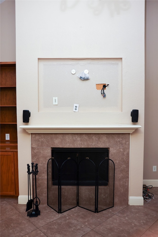 details with a tiled fireplace and tile patterned flooring