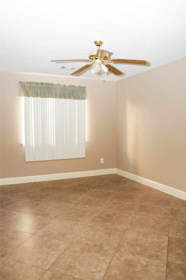 empty room featuring tile patterned floors and ceiling fan