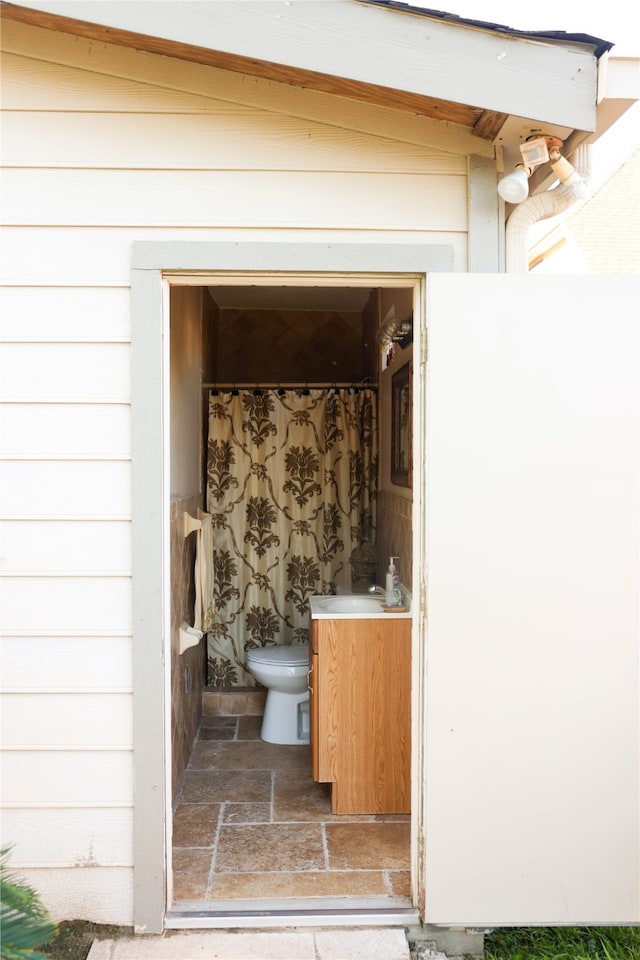 bathroom featuring toilet, vaulted ceiling, and sink