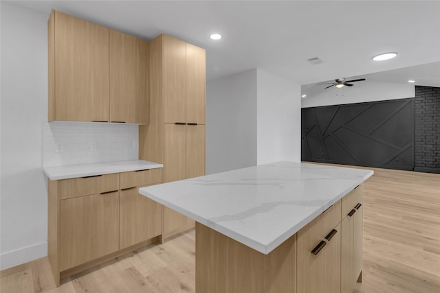 kitchen featuring ceiling fan, a center island, light wood-type flooring, and light brown cabinets