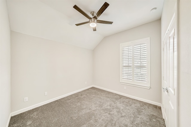 interior space featuring ceiling fan, light colored carpet, and lofted ceiling