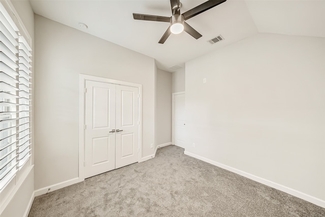 unfurnished bedroom with ceiling fan, multiple windows, and light carpet