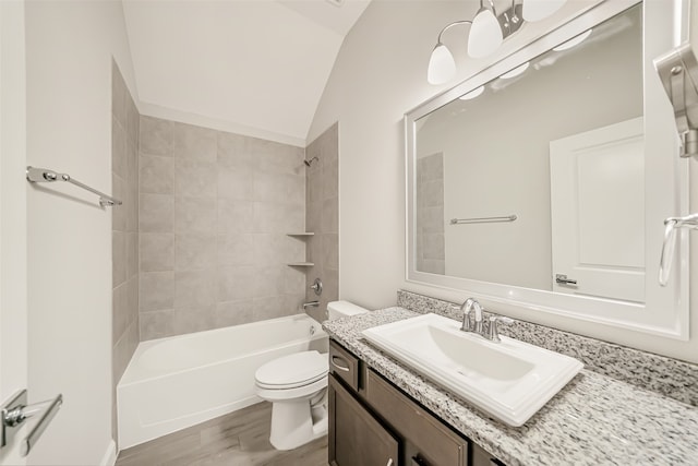 full bathroom featuring lofted ceiling, toilet, hardwood / wood-style floors, tiled shower / bath, and vanity